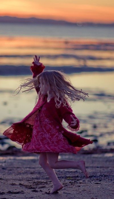little girl spinning on the beach